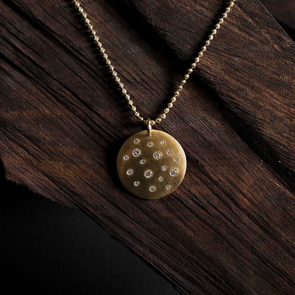 14k gold x-large MONI medallion with scattered diamonds in lookbook image